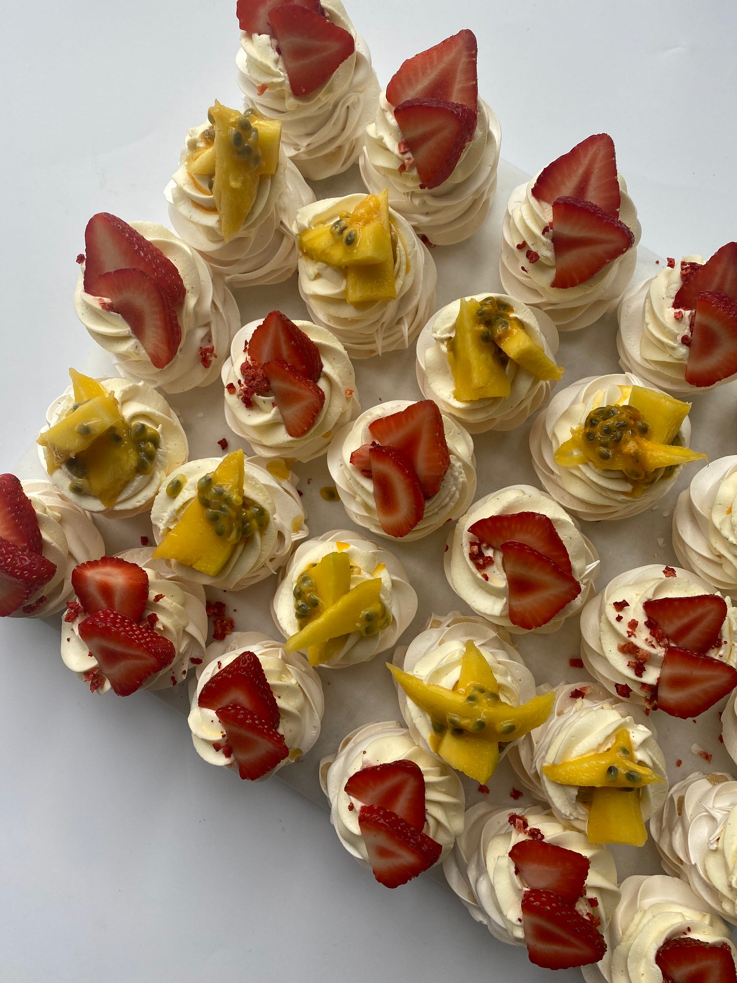 Individual mini pavlovas with cream and fresh fruit toppings