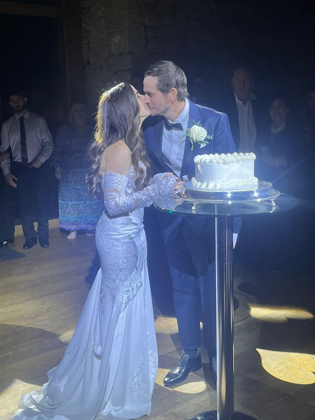 couple kissing and cutting wedding cake