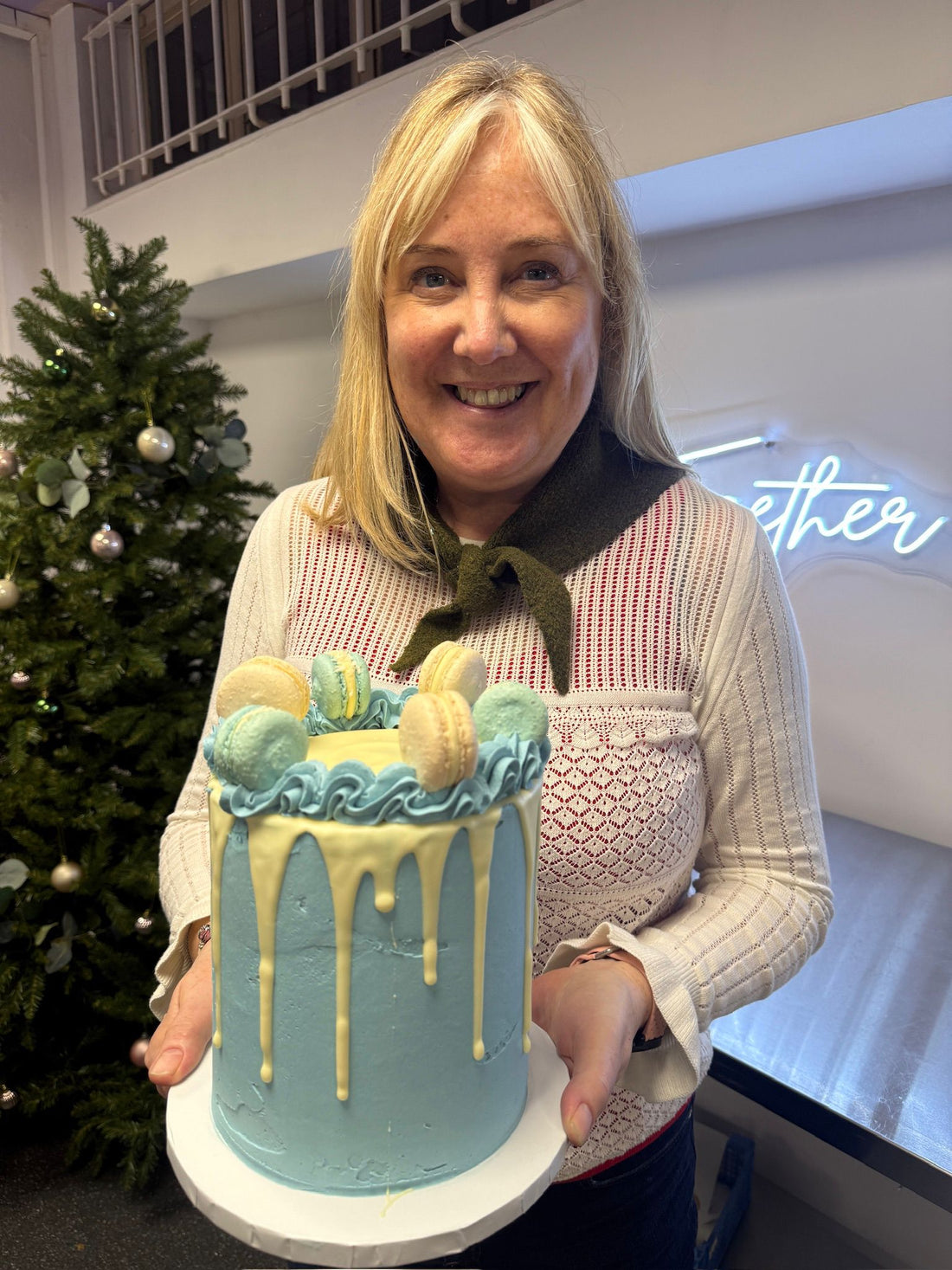 woman holding blue and white drip cake
