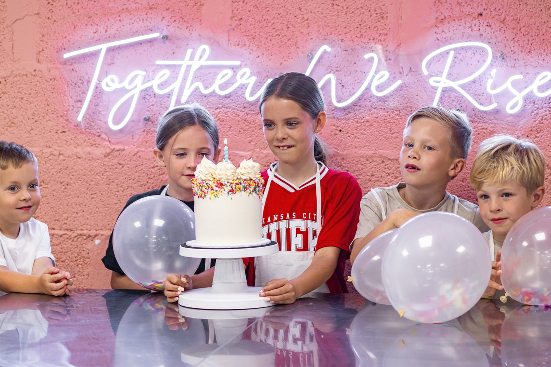 group of children with a birthday cake and candle