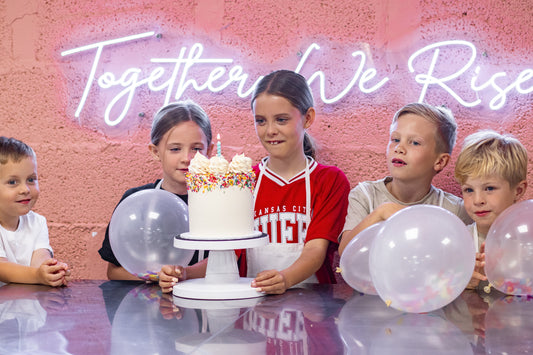 group of children with a birthday cake and candle