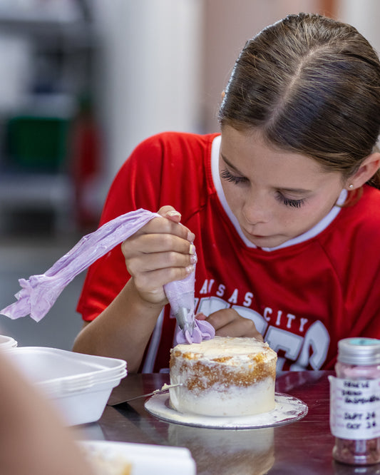 young girl decorating cake
