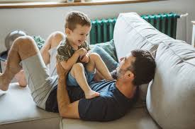 father and son playing on sofa