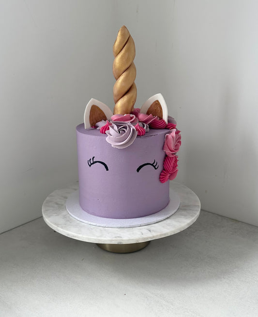 The Unicorn cake with pastel buttercream swirls and gold unicorn horn topper